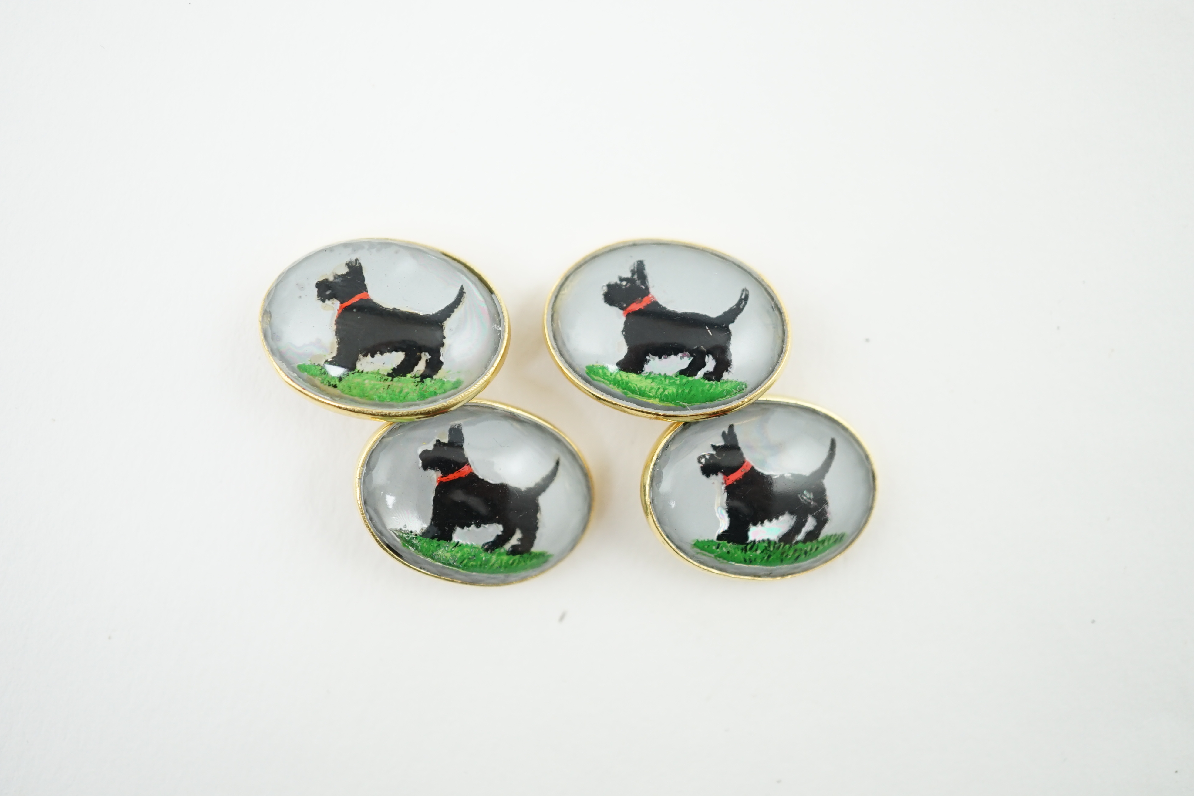 A pair of early to mid 20th century gold and Essex crystal set oval cufflinks, each decorated with a Scottie dog, 20mm, gross weight 23.4 grams. Condition - fair